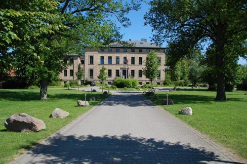 a walkway in front of a large building at Gutshaus Redewisch Hotel & Restaurant in Boltenhagen