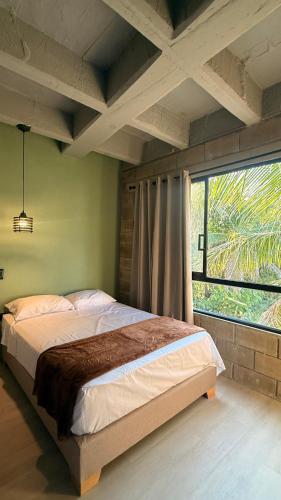 a bedroom with a bed and a large window at Aira Hotel in Coveñas