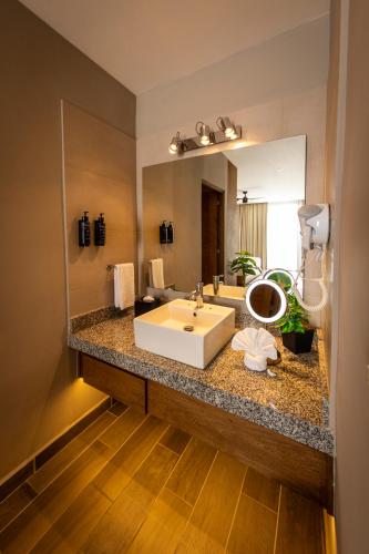 a bathroom with a sink and a large mirror at Nirú Ocean Suites by Binniguenda in Santa Cruz Huatulco