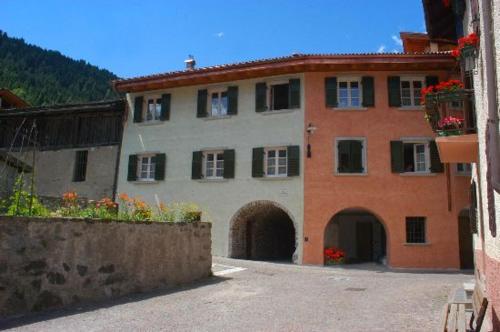 a large building with a gate and a courtyard at Residence Ca' Delle Margherite in Pellizzano
