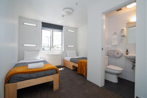 a bathroom with two beds and a toilet and a sink at The Brownston Hostel in Wanaka