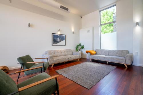 a living room with couches and chairs and a window at The Brownston Hostel in Wanaka