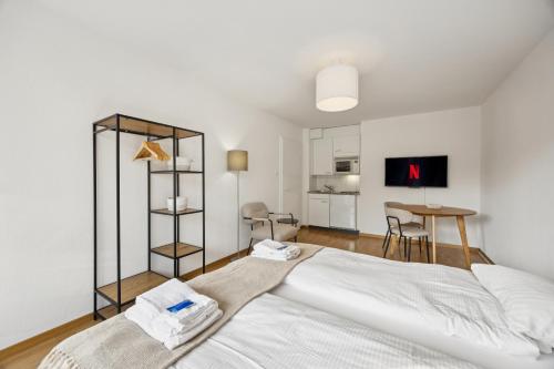 a bedroom with a large white bed and a table at Very centrally located studio - Crown 15 in Zurich
