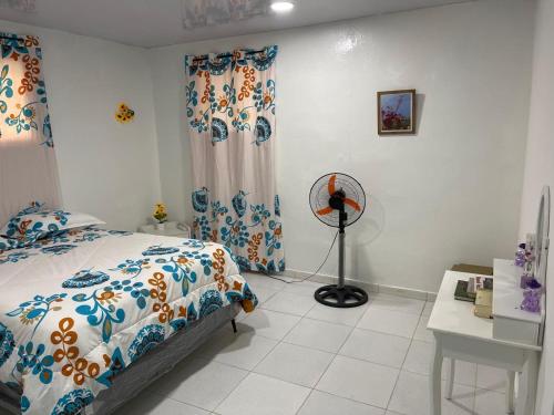 a bedroom with a bed and a desk and a fan at Rancho Doña Rita in Higuey
