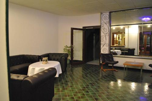 a living room with couches and a table and a mirror at Hotel "Glück Auf " in Bad Grund