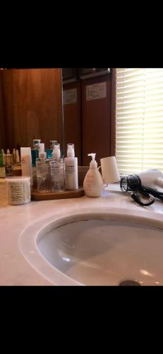 a white bathroom sink with a mirror and a phone at Private Stay in Gotemba 縁 501 in Gotemba