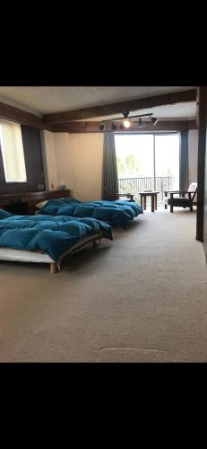 three beds in a room with a large window at Private Stay in Gotemba 縁 501 in Gotemba