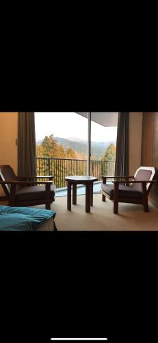 a room with a balcony with a table and benches at Private Stay in Gotemba 縁 501 in Gotemba