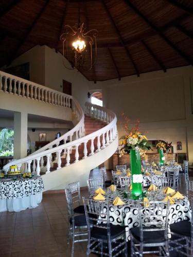 a room with tables and chairs and a staircase at Hotel Delfin Playa Bejuco in Esterillos Este