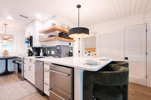 a kitchen with a counter with two bar stools at Beachfront Corner Condo With Sunset Gulf Views in Bradenton Beach