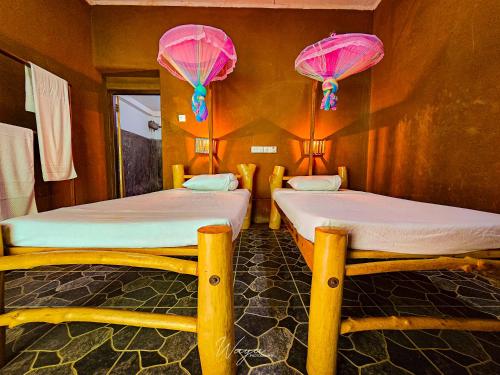 two twin beds in a room with pink lanterns at Elephant paradise Safari lodge in Udawalawe