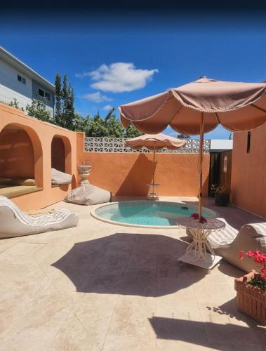 a patio with an umbrella and a swimming pool at Pacific Sun Bargara in Bargara