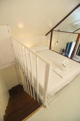 a white bunk bed in a room with a staircase at YAMA APARTMENTS - Private Beachfront in General Luna