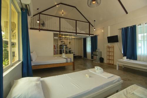 a large room with two beds and a television at YAMA APARTMENTS - Private Beachfront in General Luna