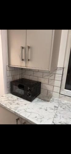 a kitchen with a black microwave on a counter at Mayford Shared House in Manchester