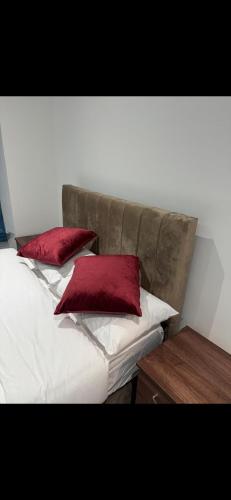 two red pillows sitting on top of a bed at Mayford Shared House in Manchester