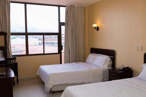 a hotel room with two beds and a large window at Hotel Novo in San José