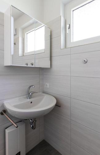 a white bathroom with a sink and a mirror at Ferienwohnung-Mour in Dahme