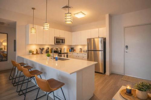 a kitchen with a large island with bar chairs at Modern 2BD DT - Balcony, Gym, W-D, Parking - Sleeps 8 in Phoenix