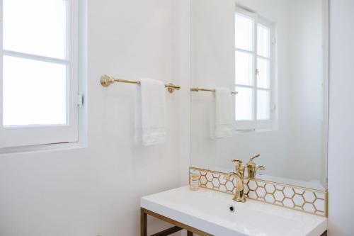 a white bathroom with a sink and a mirror at The Sovereign in Los Angeles