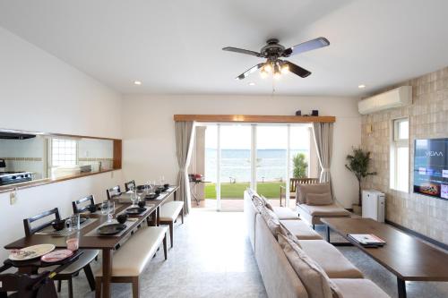 a dining room with long tables and chairs at Ocean Terrace金武 in Kin
