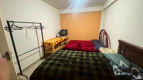 una camera da letto con un letto con un copriletto rosso di Alba Hostel a Sucre