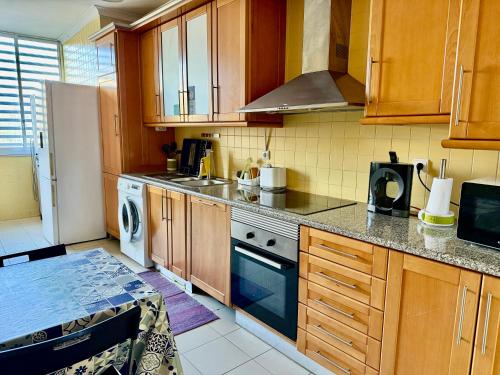 a kitchen with wooden cabinets and a stove top oven at Apartamento Coselhas Coimbra in Coimbra