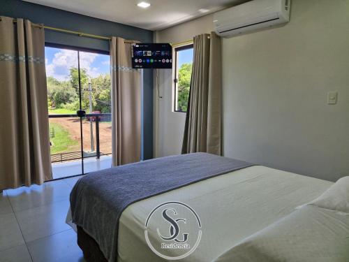 a bedroom with a bed and a large window at Residencia SG - Casa Duplex in Encarnación