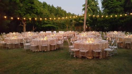 a group of tables with white chairs and lights at Hotel Delfin Playa Bejuco in Esterillos Este