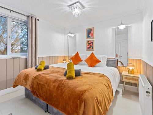 a bedroom with a large bed with yellow pillows at Churchill Apartment- 4 Beds- Free Parking- Near NEC BHX & HS2 in Coleshill