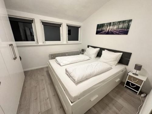 a small bedroom with a bed with white sheets and pillows at Fewo Andresen Hahnenklee in Hahnenklee-Bockswiese
