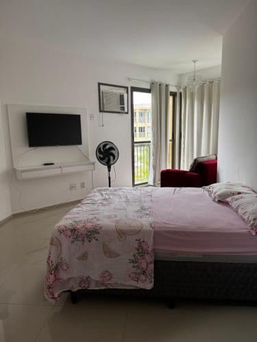 a bedroom with a bed and a flat screen tv at Loft reserva do Sahy- condado in Mangaratiba