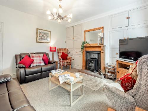 a living room with a couch and a television at Halls Bank Farm in Plumbland