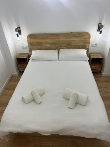 a large white bed with two pillows on it at Apartamento acogedor frente a Plaza del Cedro in Valencia