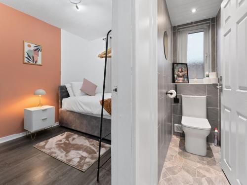 a bathroom with a bed and a toilet in a room at Churchill Apartment- 4 Beds- Free Parking- Near NEC BHX & HS2 in Coleshill