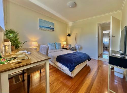 a bedroom with a bed and a desk and a television at Oakleigh Haven in Oakleigh East