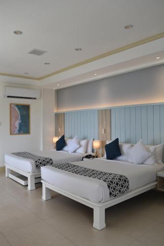 a room with two beds and a couch at Club Punta Fuego in Nasugbu
