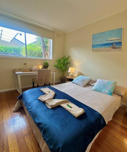 a bedroom with a large bed with towels on it at Oakleigh Haven in Oakleigh East