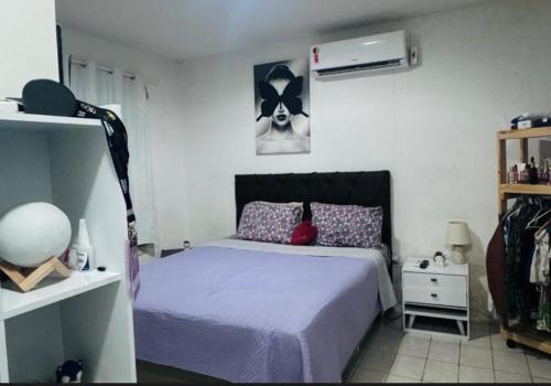 a bedroom with a bed with a purple comforter at Casa com 3 quartos carnaval Olinda in Olinda