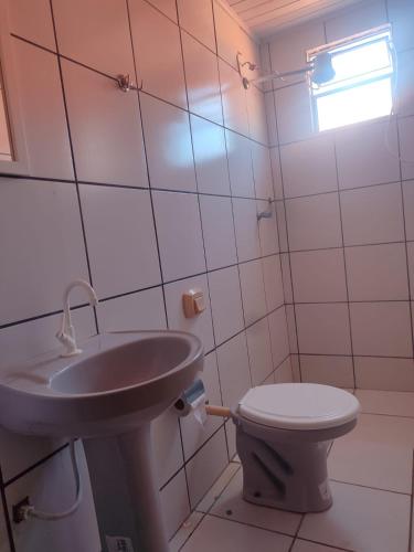 a bathroom with a sink and a toilet at Casa c 3 Suítes 4 banheiros 4 quartos climatizados a passos da Praia, Centro e comércios in Alcobaça