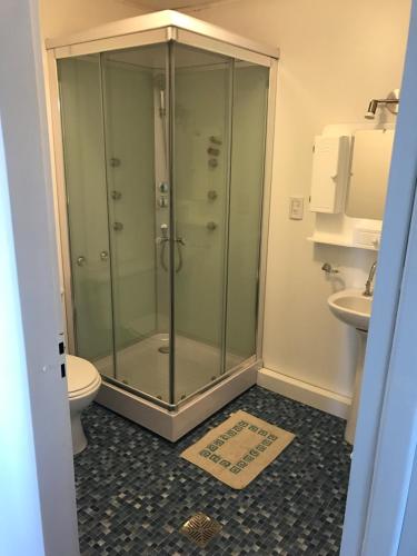 a bathroom with a shower with a toilet and a sink at Koocoland- Xumuc in Tupungato