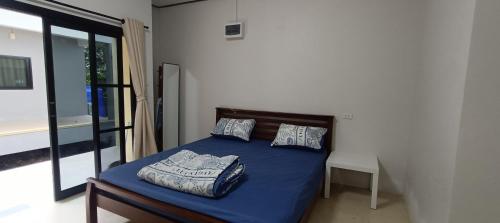 a bedroom with a bed with blue sheets and pillows at Jeab Villa Kohphangan in Ko Phangan