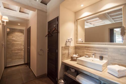 uma casa de banho com um lavatório e um espelho em Boutique Hôtel La Villa MONTESQUIEU em Laudun