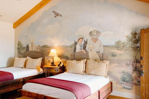 a room with two beds and a painting on the wall at Wildcatter Ranch and Resort in Graham