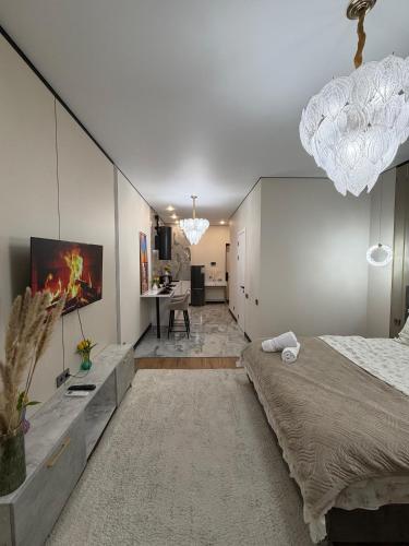 a bedroom with a large bed and a desk at The Grand CentraL Studio & Люкс Студия в Центре Города Алматы in Almaty