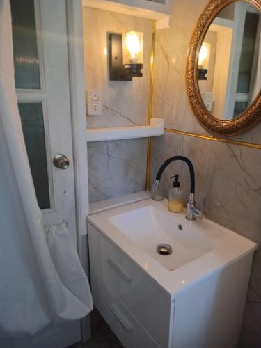 a bathroom with a white sink and a mirror at Apartamento Villa Amanecer in Villarrica