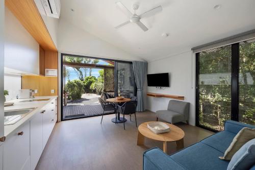 a kitchen and living room with a blue couch at Reflections Byron Bay - Holiday Park in Byron Bay