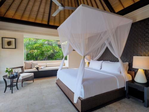 a bedroom with a bed with mosquito net at Peppers Seminyak in Seminyak