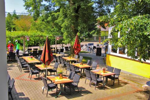 バート・ラトカースブルクにあるGasthof Zum Lindenhofのパティオ(パラソル付きのテーブルと椅子付)