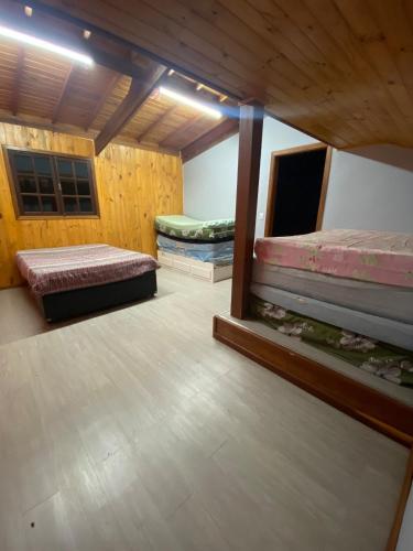 two beds in a room with wooden walls at Sítio encantador com piscina e lazer completo in São Roque